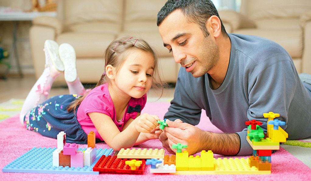Father And Little Daughter Playing With Toys Together At Home